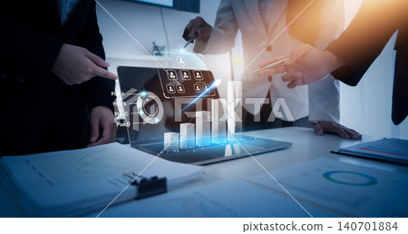 Business professionals analyzing data on holographic laptop for strategy Business professionals analyzing data on holographic laptop for strategy 140701884