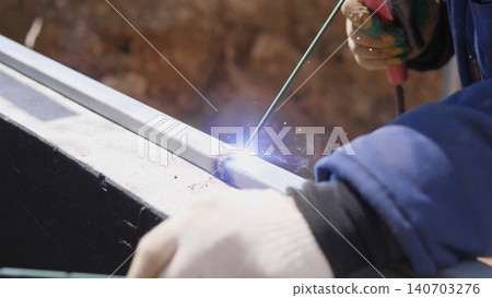 Welder Creating Structural Join With Controlled Arc And Steady Hand, Visible Seam And Sparks On Steel Beam, Industrial Site Ambiance With Focus On Precision And Craftsmanship In Heavy Duty 140703276