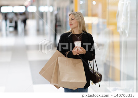 Woman enjoying retail therapy and window shopping at mall Woman enjoying retail therapy and window shopping at mall 140703333