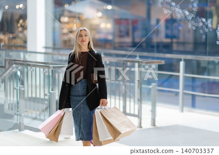 Woman enjoying shopping day carrying colorful bags 140703337