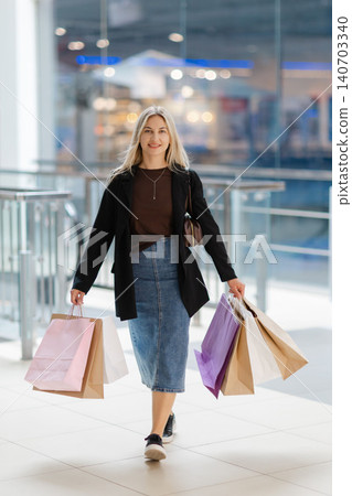 Woman walking with shopping bags in mall 140703340