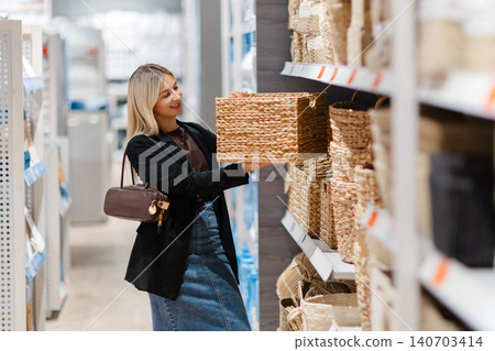 Woman choosing wicker basket for home decor in store Woman choosing wicker basket for home decor in store 140703414