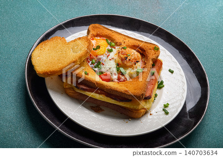Hot breakfast sandwich with fried egg cheese and sausage. Hearty morning meal and comfort food concept for brunch or cafe menu. Hot breakfast sandwich with fried egg cheese and sausage. Hearty morning meal and comfort food concept for brunch or cafe menu. 140703634
