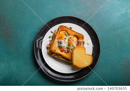 Hot breakfast sandwich with fried egg cheese and sausage. Hearty morning meal and comfort food concept for brunch or cafe menu. Hot breakfast sandwich with fried egg cheese and sausage. Hearty morning meal and comfort food concept for brunch or cafe menu. 140703635