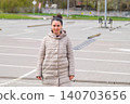 Woman standing in empty parking lot looking at camera outdoors 140703656