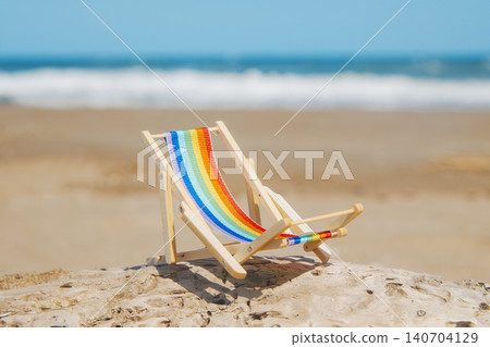 a deck chair with a rainbow seat at the beach a deck chair with a rainbow seat at the beach 140704129