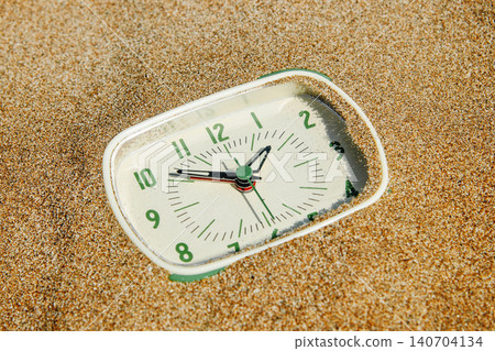 a close-up of a green clock in the sand a close-up of a green clock in the sand 140704134