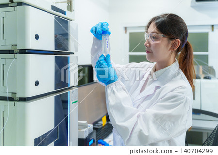 Female scientist analyzing samples in a modern laboratory using advanced technology for research and study 140704299