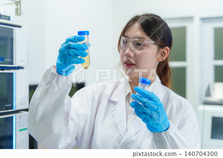 Young female scientist analyzing samples in modern laboratory using technology for research and development Young female scientist analyzing samples in modern laboratory using technology for research and development 140704300