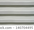 Close up texture of modern zebra roller blinds with alternating sheer and opaque fabric stripes. Minimalist window covering background for interior design concepts 140704495