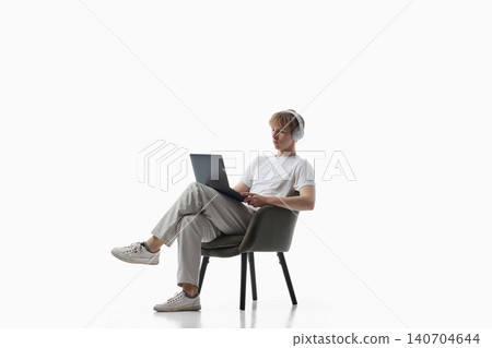 Teen boy with headphones using tablet on isolated background. 140704644