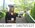 business woman looking ang checking time on smart watch in community mall garden 140705325