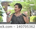elder woman strong and healthy posing and smiling in community mall garden 140705362