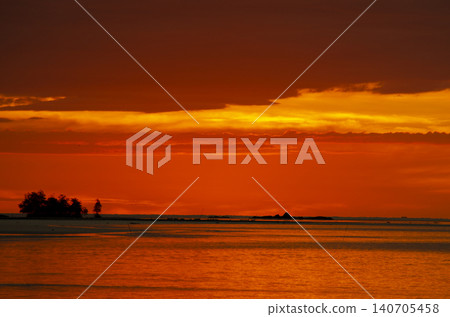 Vibrant Borneo sunset over calm waters featuring intense orange and red hues across the evening sky Vibrant Borneo sunset over calm waters featuring intense orange and red hues across the evening sky 140705458