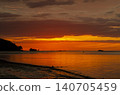 Brilliant sunset over the sea with glowing orange reflections stretching across the water toward the horizon 140705459