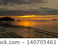 Serene beach shoreline with gentle waves and expansive blue sky showcasing a tranquil coastal landscape scene 140705461
