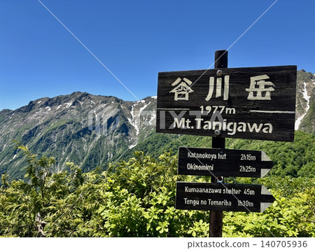 The summit marker of Mt. Tanigawa and the fresh greenery with lingering snow on a perfectly clear, cloudless day at Mt. Tanigawa (Minakami Town, Gunma Prefecture) 140705936