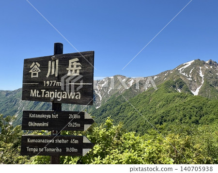 The summit marker of Mt. Tanigawa and the fresh greenery with lingering snow on a perfectly clear, cloudless day at Mt. Tanigawa (Minakami Town, Gunma Prefecture) 140705938