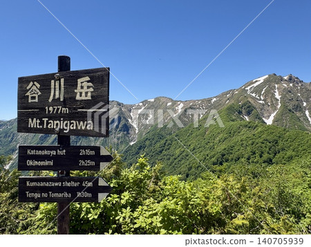 The summit marker of Mt. Tanigawa and the fresh greenery with lingering snow on a perfectly clear, cloudless day at Mt. Tanigawa (Minakami Town, Gunma Prefecture) 140705939