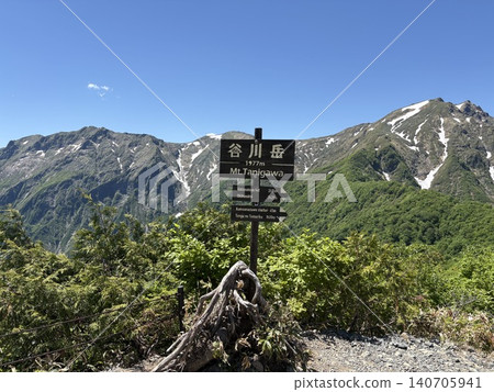 The summit marker of Mt. Tanigawa and the fresh greenery with lingering snow on a perfectly clear, cloudless day at Mt. Tanigawa (Minakami Town, Gunma Prefecture) The summit marker of Mt. Tanigawa and the fresh greenery with lingering snow on a perfectly clear, cloudless day at Mt. Tanigawa (Minakami Town, Gunma Prefecture) 140705941