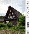 Traditional Japanese houses with thatched roofs and lush natural scenery that evoke the quintessential Japanese landscape. 140705984