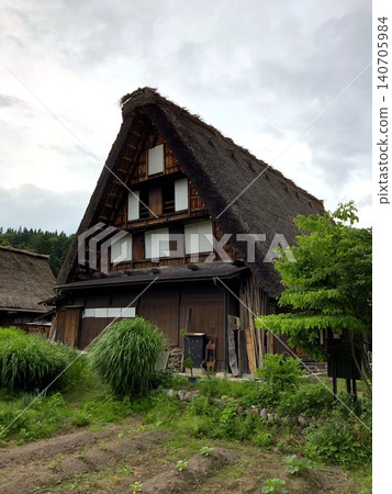 傳統的日式茅草屋頂房屋和鬱鬱蔥蔥的自然景觀,展現了典型的日本風景。 傳統的日式茅草屋頂房屋和鬱鬱蔥蔥的自然景觀,展現了典型的日本風景。 140705984