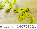 Yellow measuring tape arranged on a wooden surface representing fitness progress measurement 140706121