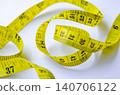 Coiled yellow measuring tape displayed prominently as a symbol of dieting and personal fitness achievements 140706122