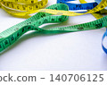 Green and blue measuring tapes layered together with customizable space for text. 140706125