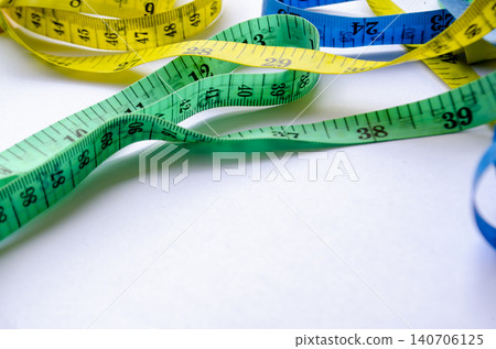 Green and blue measuring tapes layered together with customizable space for text. 140706125
