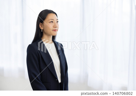 A young Japanese businesswoman looking out the window. A young Japanese businesswoman looking out the window. 140706802