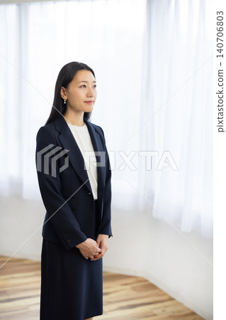 A young Japanese businesswoman looking out the window. A young Japanese businesswoman looking out the window. 140706803
