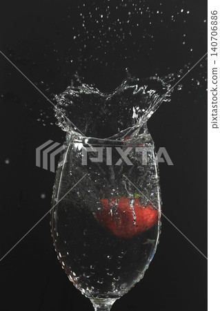 Strawberries fall into the glass, creating heart-shaped splashes. 140706886
