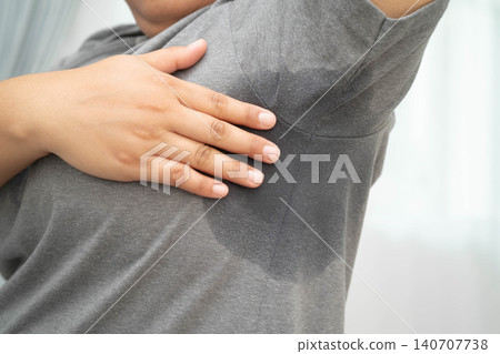 Sweaty underarms, Asian woman with sweat on clothes under armpit. Sweaty underarms, Asian woman with sweat on clothes under armpit. 140707738