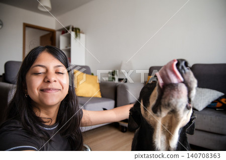 Teen Girl Taking Selfie and Hugging Dog on Living Room Sofa Teen Girl Taking Selfie and Hugging Dog on Living Room Sofa 140708363