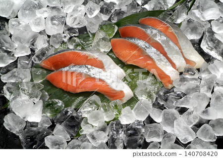 An image of fresh, wild sockeye salmon fillets arranged against a backdrop of ice and haran leaves. An image of fresh, wild sockeye salmon fillets arranged against a backdrop of ice and haran leaves. 140708420