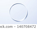 A glass circle on a blue background. A template for placing samples of cosmetics or medical products or food. 140708472