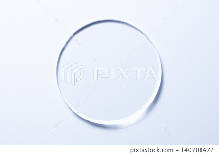 A glass circle on a blue background. A template for placing samples of cosmetics or medical products or food. A glass circle on a blue background. A template for placing samples of cosmetics or medical products or food. 140708472