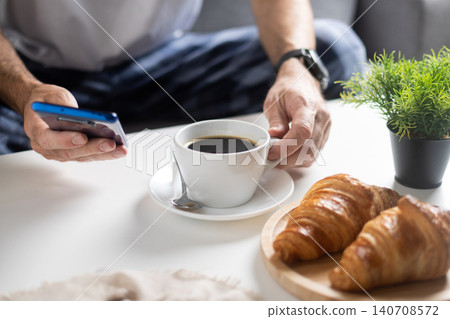Using Smartphone During Breakfast with Coffee and Croissants Using Smartphone During Breakfast with Coffee and Croissants 140708572