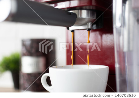 Fresh Espresso Coffee Pouring Into White Cup From Red Coffee Machine Fresh Espresso Coffee Pouring Into White Cup From Red Coffee Machine 140708630