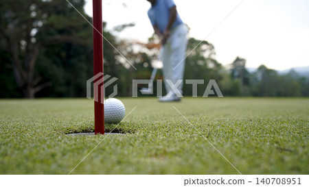 Golfers are putting golf in the evening golf course golf backglound. 140708951