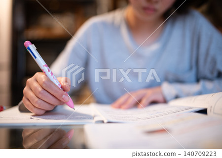 一名中學生在室內用鋼筆專心致志地在筆記本上寫字-學習/研究 一名中學生在室內用鋼筆專心致志地在筆記本上寫字-學習/研究 140709223