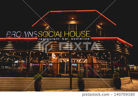 Exterior of Illuminated Modern architecture of the Browns Social House bar restaurant at night in Surrey Canada. Nobody, street photo, editorial. Jun 26,2022 Exterior of Illuminated Modern architecture of the Browns Social House bar restaurant at night in Surrey Canada. Nobody, street photo, editorial. Jun 26,2022 140709380
