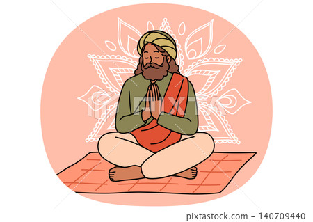 Meditating Indian man fakir prays sitting cross-legged on mat with mandala sign behind back. 140709440
