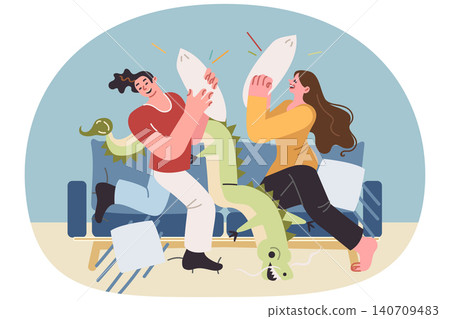 Carefree couple fights with pillows, sitting on sofa, enjoying pleasure of relaxing together Carefree couple fights with pillows, sitting on sofa, enjoying pleasure of relaxing together 140709483