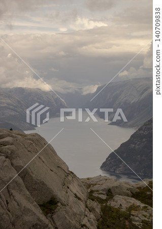 Person admiring lysefjord panoramic view from pulpit rock Person admiring lysefjord panoramic view from pulpit rock 140709838