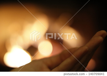 Hand receiving warmth from glowing bokeh lights Hand receiving warmth from glowing bokeh lights 140709841