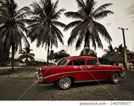 Red vintage car parked under palm trees in cuba 140709877