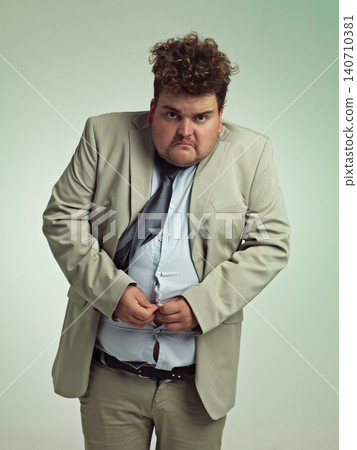 Portrait, plus size and man with stomach in shirt for suit, professional and annoyed with clothes for work. Employee, male person and guy with unhappy with fail of belly in attire for job in studio Portrait, plus size and man with stomach in shirt for suit, professional and annoyed with clothes for work. Employee, male person and guy with unhappy with fail of belly in attire for job in studio 140710381