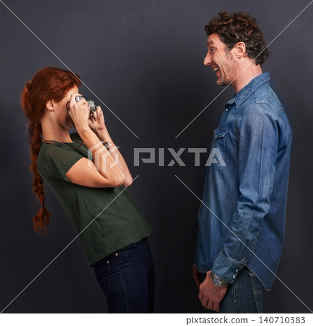 Photography, camera and woman with man in studio with fun, love and romantic date together. Hobby, smile and young female photographer with dslr equipment with boyfriend isolated by black background. 140710383